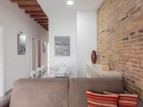 a living room with a couch and a brick wall at Stay U-nique Apartments Nació in Barcelona