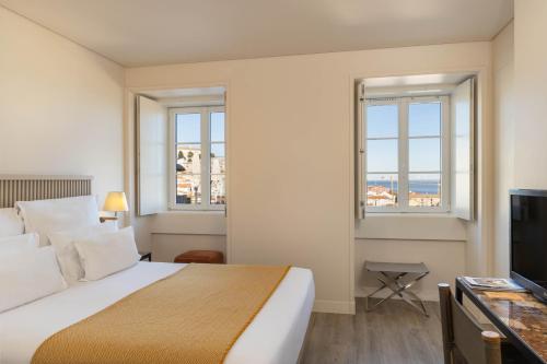 a hotel room with a bed and a television at Memmo Alfama - Design Hotels in Lisbon