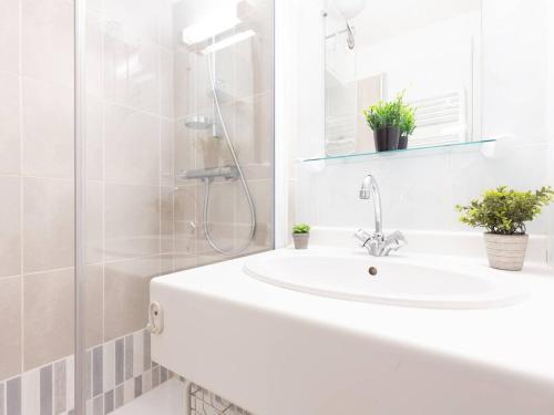 une salle de bain blanche avec un lavabo et une douche dans l'établissement Appartement calme avec jardin, 6 pers, près du centre et des pistes - Saint-Lary Village - FR-1-296-173, à Saint-Lary-Soulan