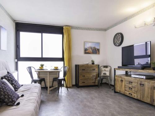 un salon avec un canapé, une table et une télévision dans l'établissement Studio proche pistes ski avec parking, lumineux et calme - FR-1-296-330, à Saint-Lary-Soulan