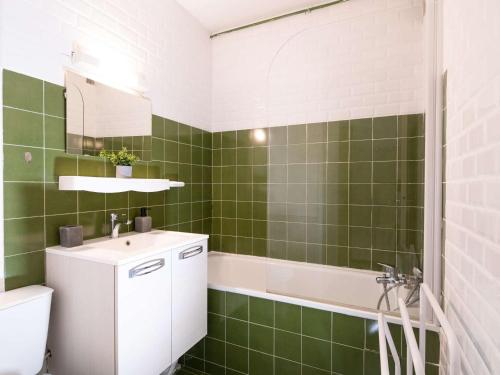 a green tiled bathroom with a sink and a tub at Studio cosy à Saint-Lary-Soulan, ski aux pieds - FR-1-296-330 in Saint-Lary-Soulan