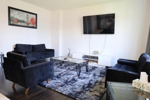 - un salon avec deux canapés bleus et une télévision dans l'établissement Brand new luxurious home, located in Lindsay., à Kawartha Lakes