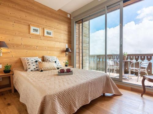 une chambre avec un lit et une grande fenêtre dans l'établissement Appart 7p Pieds de Pistes avec Piscine Chauffée - FR-1-296-345, à Saint-Lary-Soulan