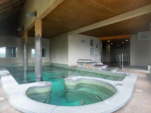 une grande piscine d'eau dans un bâtiment dans l'établissement Appart 7p Pieds de Pistes avec Piscine Chauffée - FR-1-296-345, à Saint-Lary-Soulan