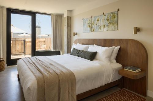 a bedroom with a large bed and a balcony at Drift Nashville, a Member of Design Hotels in Nashville