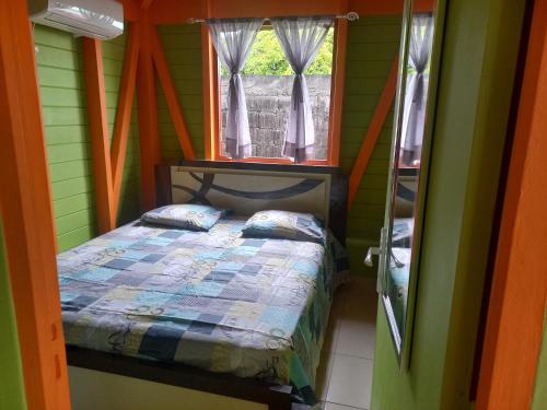 une chambre avec un lit dans une pièce avec une fenêtre dans l'établissement Faty LOCATION, à Petit-Bourg