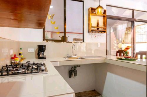 a white kitchen with a stove and a sink at Casa en Playa Tambor - A 5 minutos de la playa in Tambor