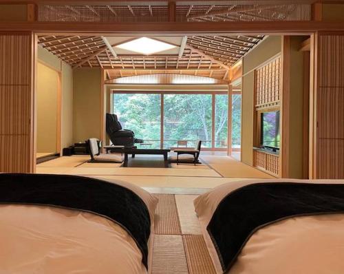 a room with two beds and a living room at Akazawa Geihinkan in Ito