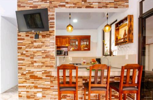 cocina con pared de ladrillo y mesa con sillas en Casa en Playa Tambor - A 5 minutos de la playa en Tambor