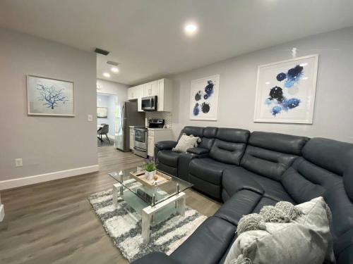a living room with a black leather couch and a table at Rachaels Upscale 3 bedrooms Luxury Home in Fort Lauderdale