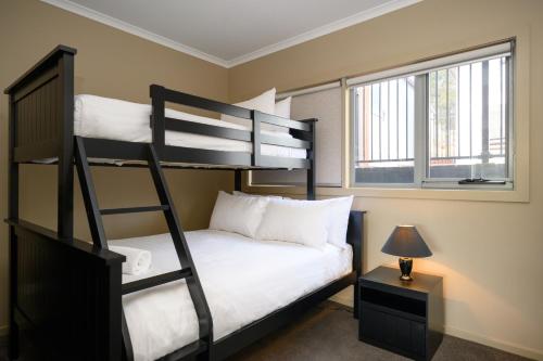 a bedroom with a bunk bed with a ladder at Coastal Nest a perfect retreat! in Coles Bay