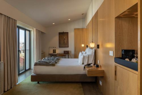 a hotel room with a bed and a large window at Memmo Príncipe Real - Design Hotels in Lisbon