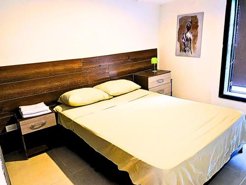 a bedroom with a large bed with a wooden headboard at La cabaña in Pereira