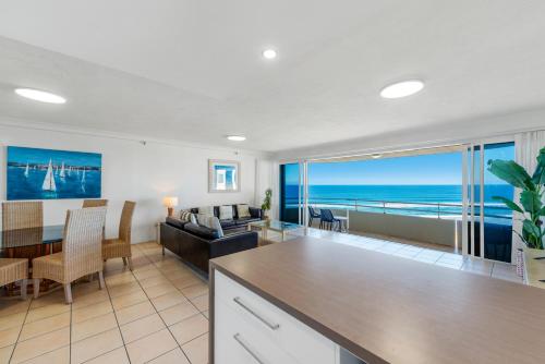 a kitchen and living room with a view of the ocean at Zenith Ocean Front Apartments in Gold Coast