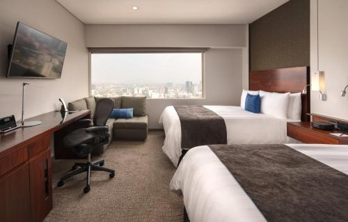 a hotel room with two beds and a desk at Presidente InterContinental Mexico City by IHG in Mexico City