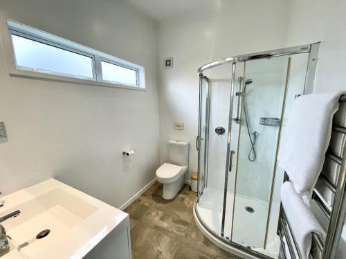 une salle de bains avec douche, toilettes et lavabo dans l'établissement Sailor's Cottage - Stay Waiheke, à Blackpool
