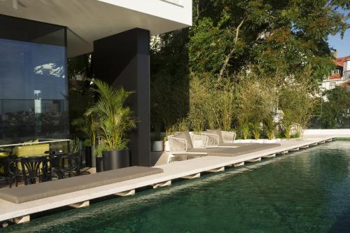 - une vue extérieure sur une maison avec une piscine dans l'établissement Memmo Príncipe Real - Design Hotels, à Lisbonne