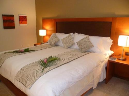 ein großes weißes Bett in einem Zimmer mit zwei Lampen in der Unterkunft Pascana Hotel in Santa Cruz de la Sierra
