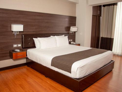ein Schlafzimmer mit einem großen Bett in einem Hotelzimmer in der Unterkunft Pascana Hotel in Santa Cruz de la Sierra