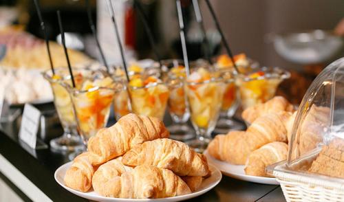 a buffet with plates of croissants and other pastries at Pascana Hotel in Santa Cruz de la Sierra