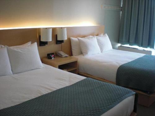 ein Hotelzimmer mit 2 Betten und einem Telefon in der Unterkunft Pascana Hotel in Santa Cruz de la Sierra