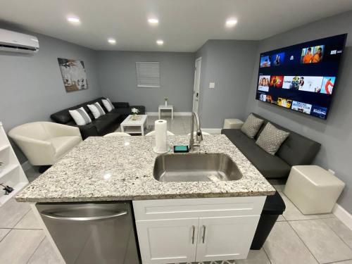a kitchen with a sink and a living room at Executive Luxury Suite in Fort Lauderdale
