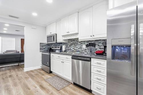 a kitchen with white cabinets and a stainless steel refrigerator at Luxury home in Fort Lauderdale