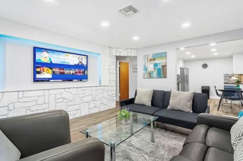 a living room with a couch and a tv on a wall at Luxury home in Fort Lauderdale