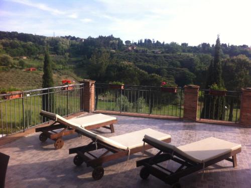 a patio with two chaise lounges and a view of a mountain at Garden Relais Le Fontanelle in Montescudaio