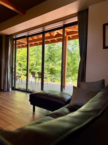 a living room with a couch and a large window at Private Villa ietona in Fujikawaguchiko