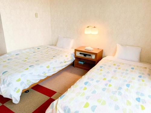 - une chambre avec 2 lits et une table de nuit avec un téléphone dans l'établissement Hotel Royal Kitami - Vacation STAY 06513v, à Kitami