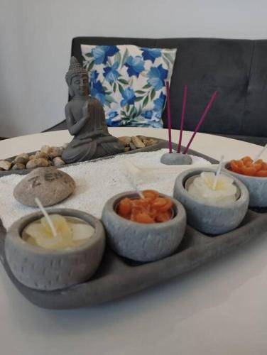 a tray with four bowls of food on a table with a statue at Suite acogedora en Ibarra in Ibarra