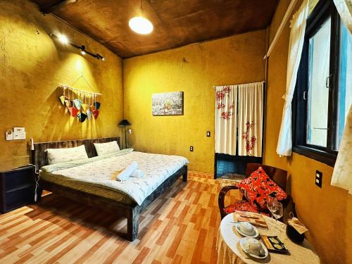 a bedroom with a bed and a chair in it at Maison de Hill Home in Dồng Văn