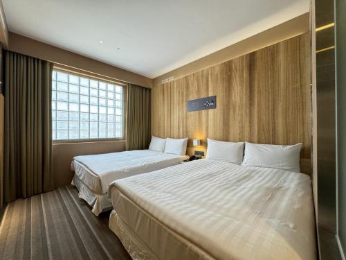 a hotel room with two beds and a window at 路境行旅 台南西門館 Finders Hotel Tainan Ximen in Tainan