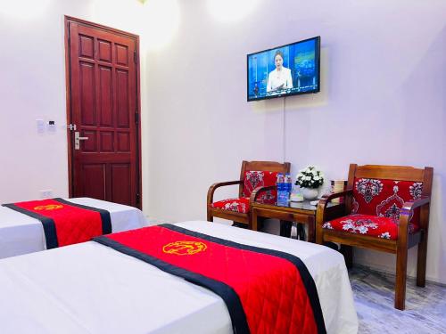 a room with two beds and a tv on the wall at TITANIC 3 HOTEL in Hậu Dương