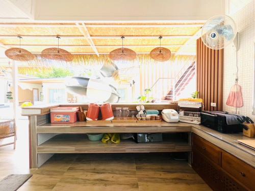 a kitchen with a counter with many items at Villa De Phawa in Samut Songkhram