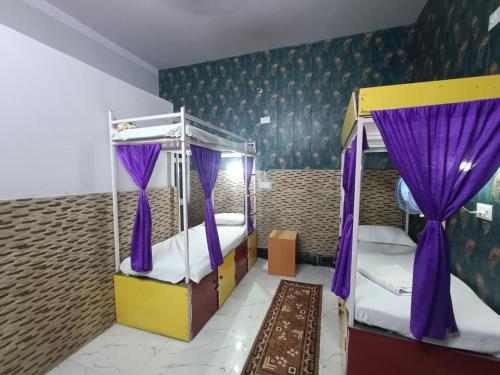 sypialnia z 2 łóżkami piętrowymi i fioletowymi zasłonami w obiekcie Mohit Paying Guest house w mieście Waranasi