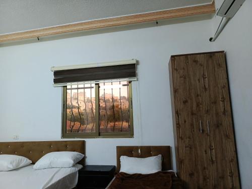 1 Schlafzimmer mit 2 Betten und einem Fenster in der Unterkunft Jerash ruins hotel in Gerasa