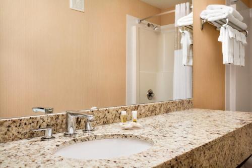 baño con lavabo y espejo grande en Days Inn & Suites by Wyndham Cochrane, en Cochrane