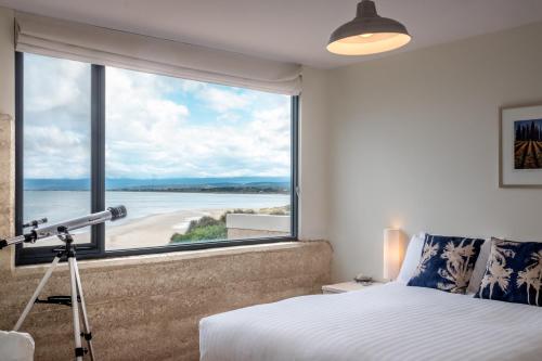 a bedroom with a large window with a telescope at Sea View ~ ultimate beachside retreat! in Coles Bay