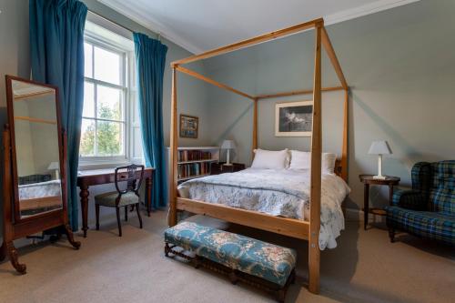 a bedroom with a canopy bed and a chair at Tarbert Country Manor in Tarbert