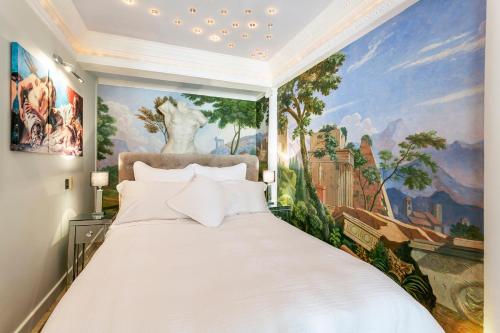 a bedroom with a large white bed with a painting at The Breakers - Riviera Apartment in Sandgate