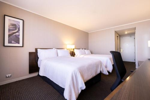a hotel room with two beds and a table at Holiday Inn Express - Iquique by IHG in Iquique