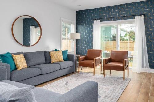 a living room with a couch and chairs and a mirror at Be A Nomad - Perfect for groups - Brand New in Jacksonville Beach