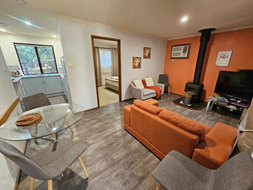 a living room with a couch and a glass table at Barossa Country Cottages in Lyndoch