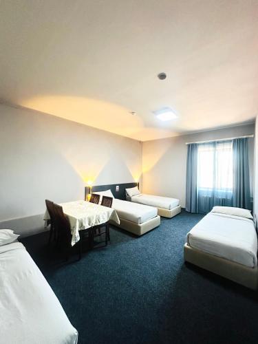 a hotel room with three beds and a window at Destiny Hotel in Harhorin