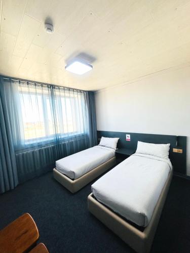 a room with two beds and a window at Destiny Hotel in Harhorin