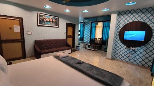1 dormitorio con cama, sofá y TV en SPOT ON Pachmarhi Hills en Pachmarhī