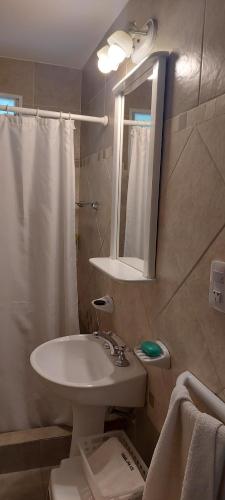 een badkamer met een wastafel, een toilet en een spiegel bij Luna Azul in Merlo