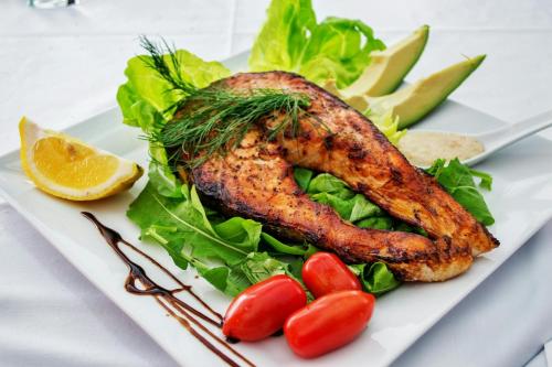 um prato de comida com um pedaço de peixe e vegetais em Heritage care hotel em Split